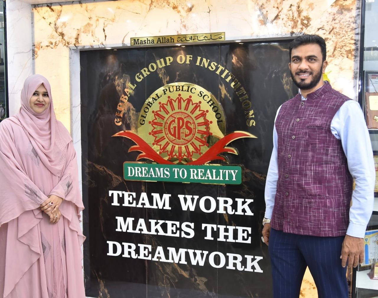 Staff beside the Global Public School emblem
