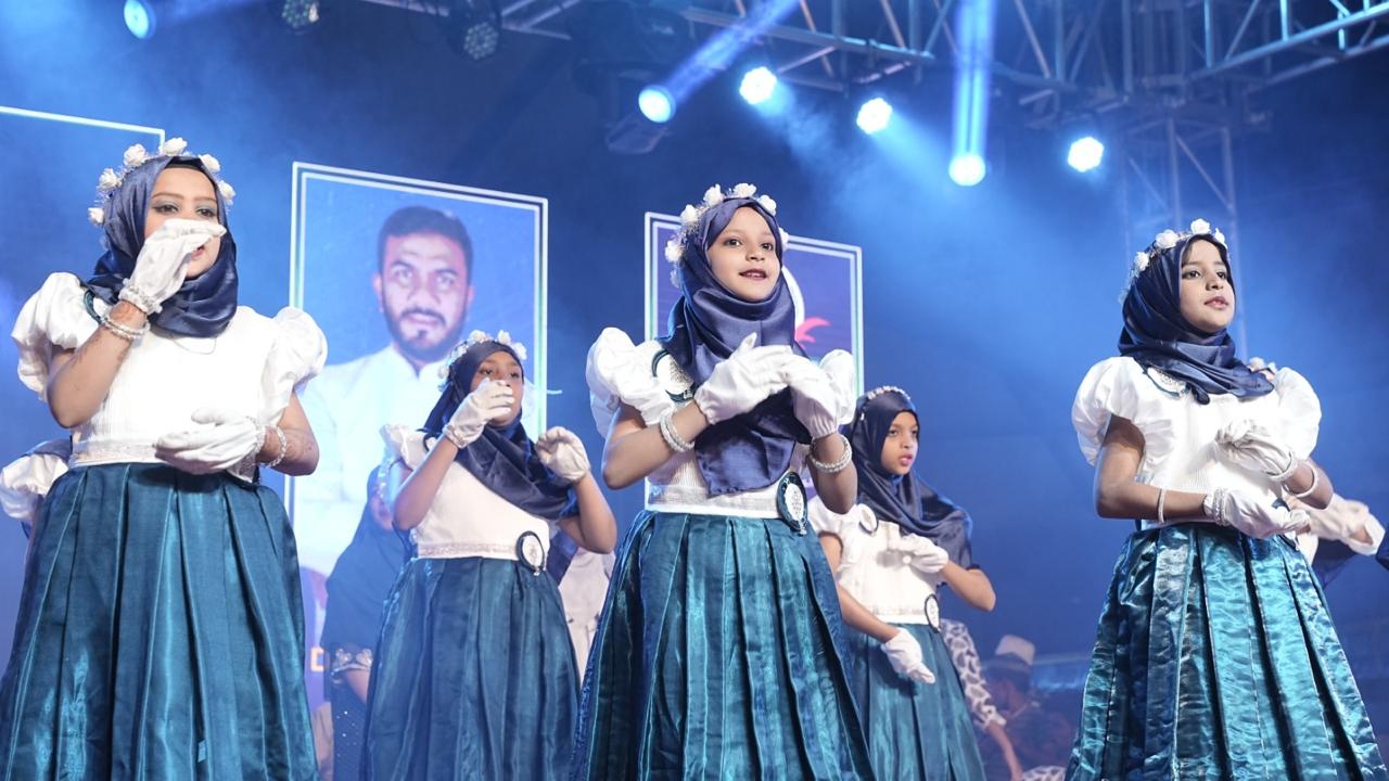 Girls performing a dance in teal costumes