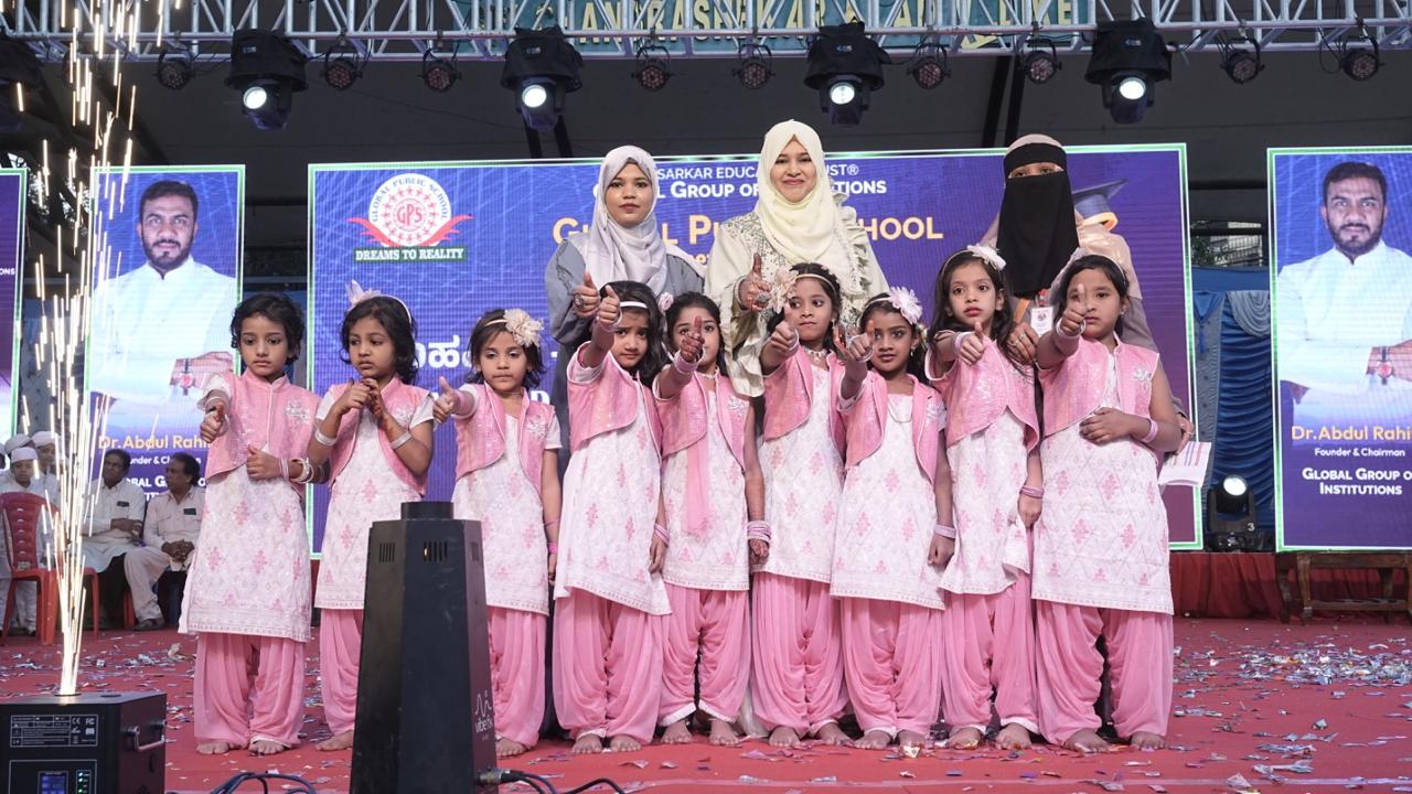 Little girls in pink posing on stage