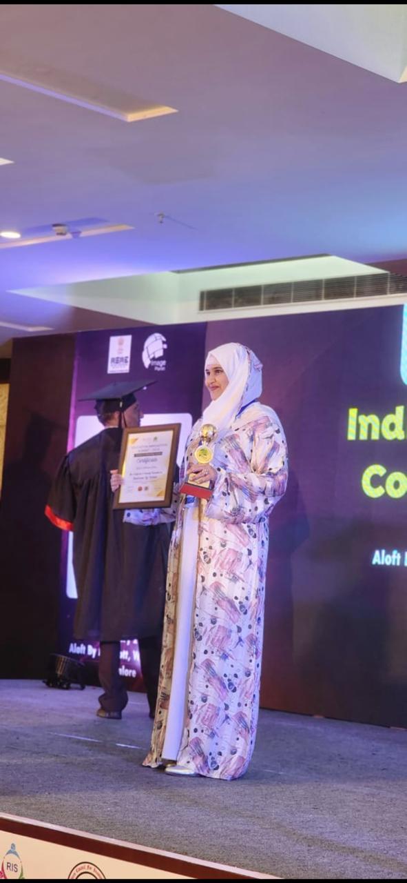 Educator receives a certificate and trophy on stage